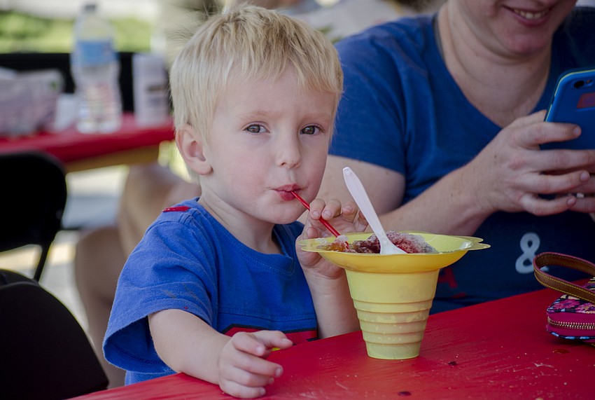 Ben Krblich drinks a slushy at St. Martha Catholic School'    s Cajun Crawfish and Seafood Festival.