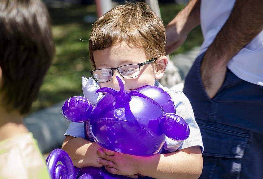 Austin Daley hugs an inflatable toy he got at St. Martha Catholic School'    s Cajun Crawfish and Seafood Festival.