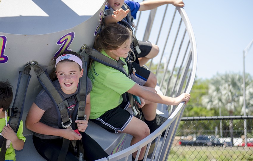 Nyah Andrews and Morgan Reyes ride a carnival ride at St. Martha Catholic School'    s Cajun Crawfish and Seafood Festival.