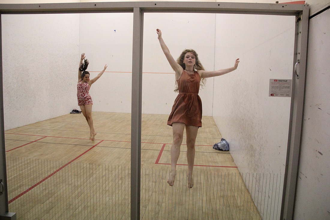 Members of the Bubble Dance Co. performing their work set inside a racquetball court.