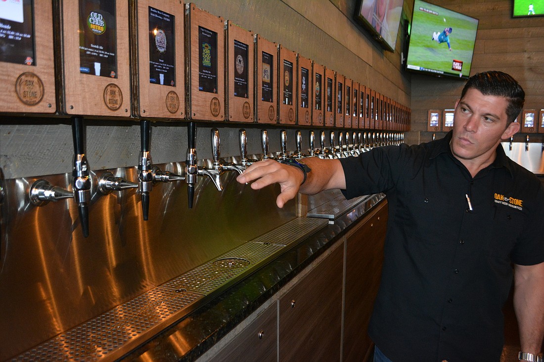 Anthony Liakakos, the general manager at Oak & Stone, shows off the iPourIt beer system.