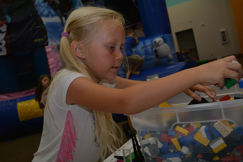 Kayden Holt, 6, eagerly picks out blocks for her Lego-like creation.