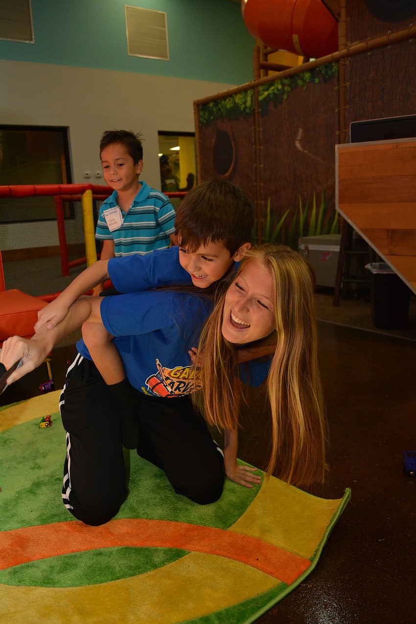 Shelby Ryskamp gets into a tickle war with Dominic Salazar, who climbed atop her back.