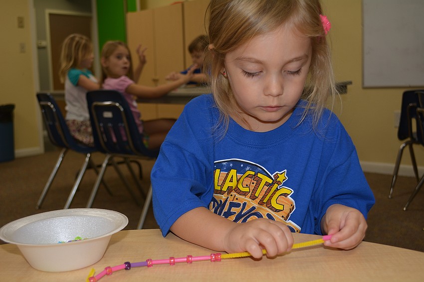 Three-year-old Ella Caggiano completes a craft. She says she most loves singing during VBS.