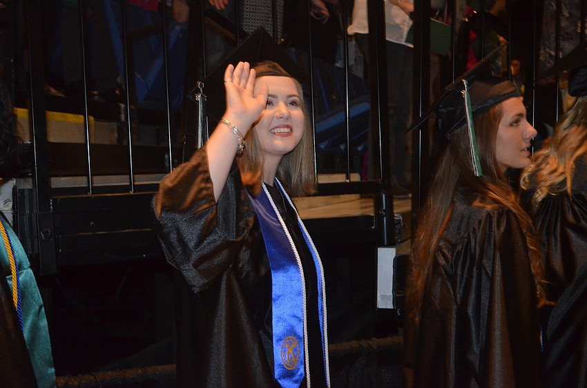 Alexis Carroll waves to her family before the ceremony.