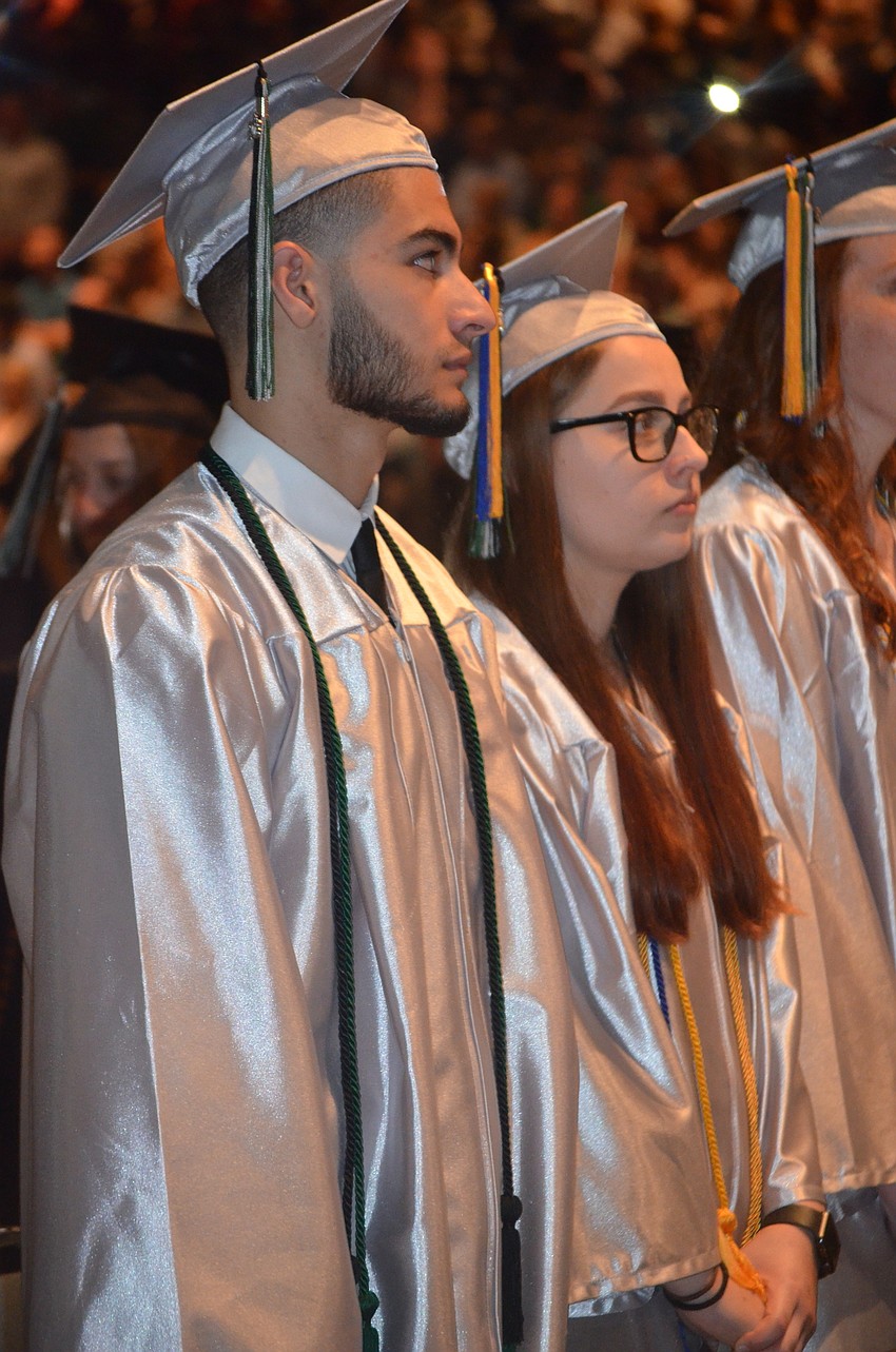 Tav Ortiz and Lauren Parent listen as Principal Craig Little honors the class.