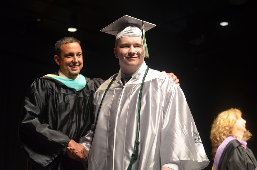 Principal Craig Little congratulates Connor Catlett as he crosses the stage to receive his diploma.