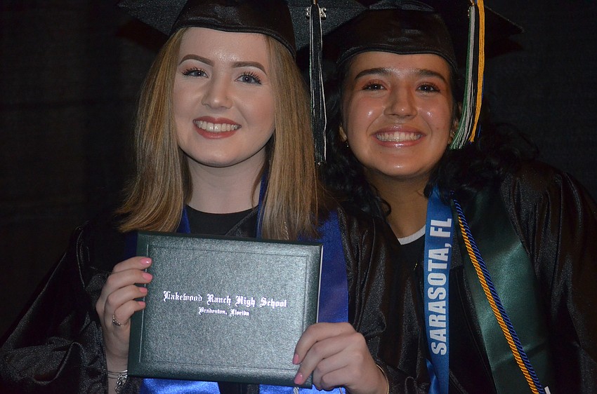 Alexis Carroll shows off her diploma with fellow graduate Sophia Lopez.