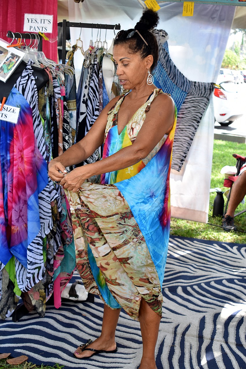 Lucy Gabriel shows customers different ways to tie dresses in her booth.