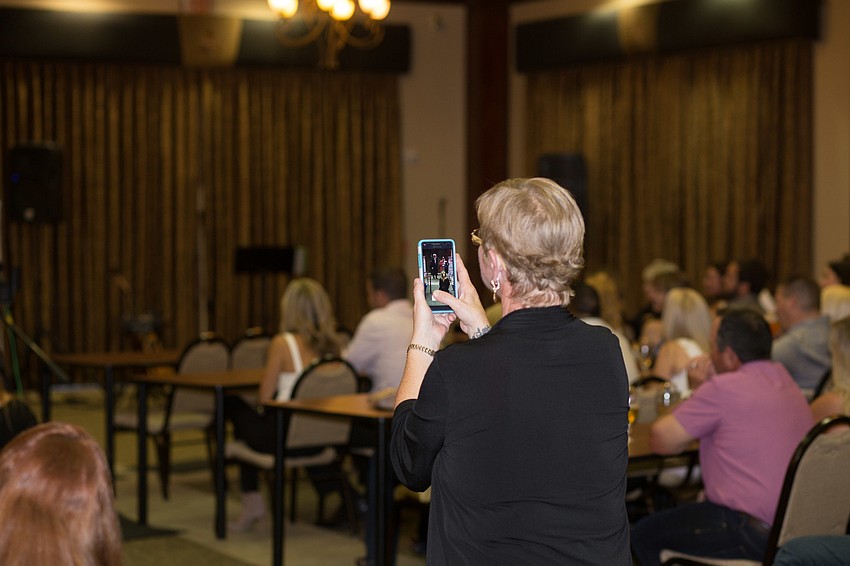 Heather Drake takes a video of her father, Clarence Addy, giving his speech.