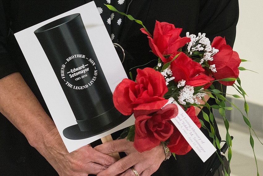 Sarasota Vice-Mayor Jen Ahearn-Koch holds a top hat and roses in honor of Eddie Sotomayor whose nickname was 