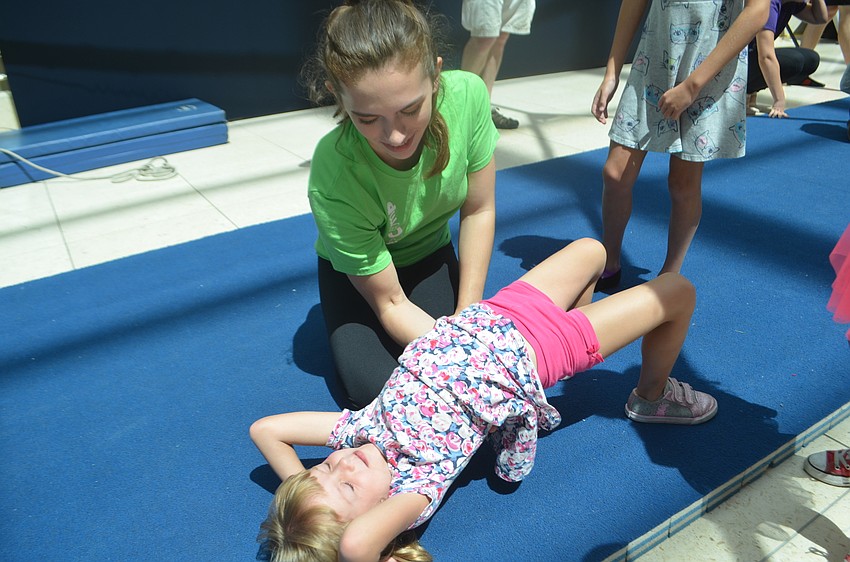 Sailor Circus Academy's Teresa Powell, 16,  helps Parrish's Riley Zawacki, 4, learn how to do a back bend,  a basic tumbling technique.