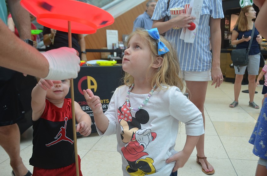 University Park's Harper Lassiter, 3, and her 1-year-old brother, Jackson, stares at the spinning plate.