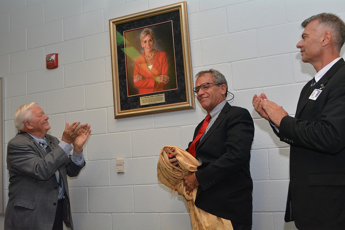 MTC Board of Governors member Dr. Richard Conard, Priscilla Haflich&#39;s son Rick  Farmer and Manatee County School&#39;s Executive Director of Adult, Career and Technical Education Doug Wagner unveil a portrait of Haflich.