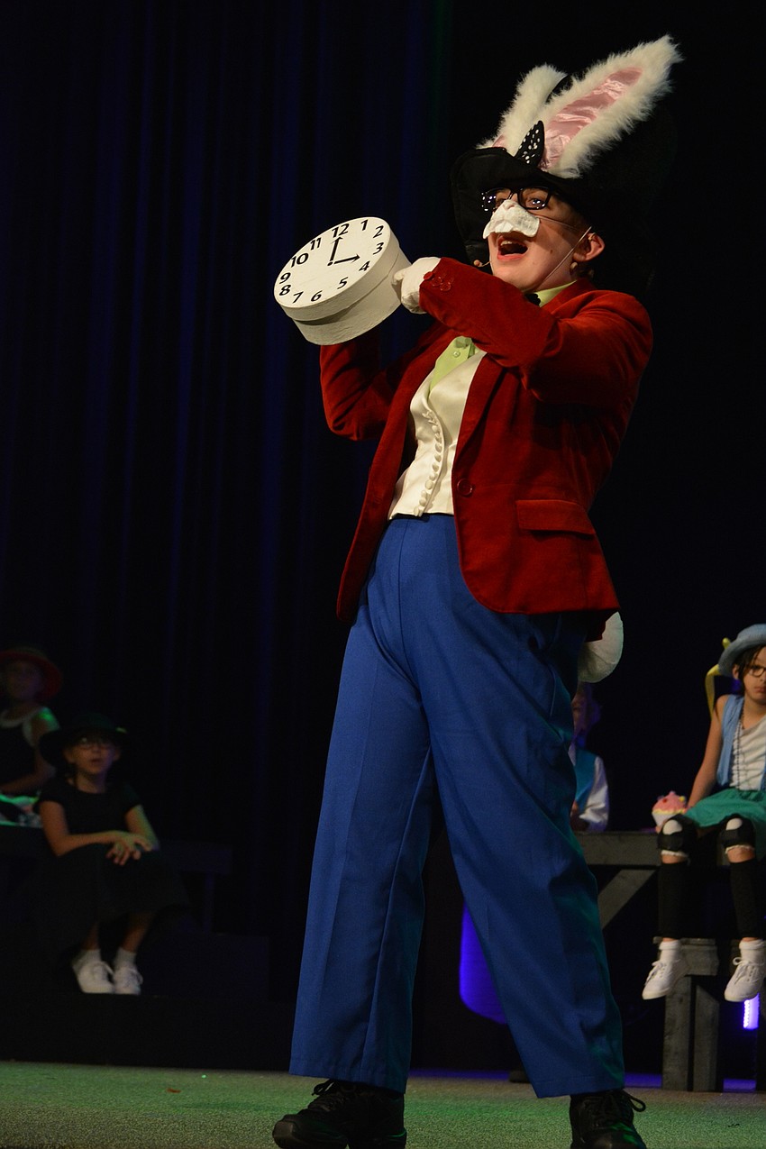 White Rabbit, portrayed by Faith Kennedy, interrupts Mad Hatter's unbirthday party and complains about being late.