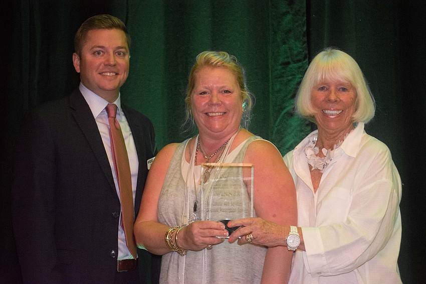 Lakewood Ranch Medical Center CEO Andy Guz presents the Healthcare and Wellness Organization of the Year Award to Samantha Hobbes and Dulcy Kushmore of Canada Med Services/Discount Prescription Services