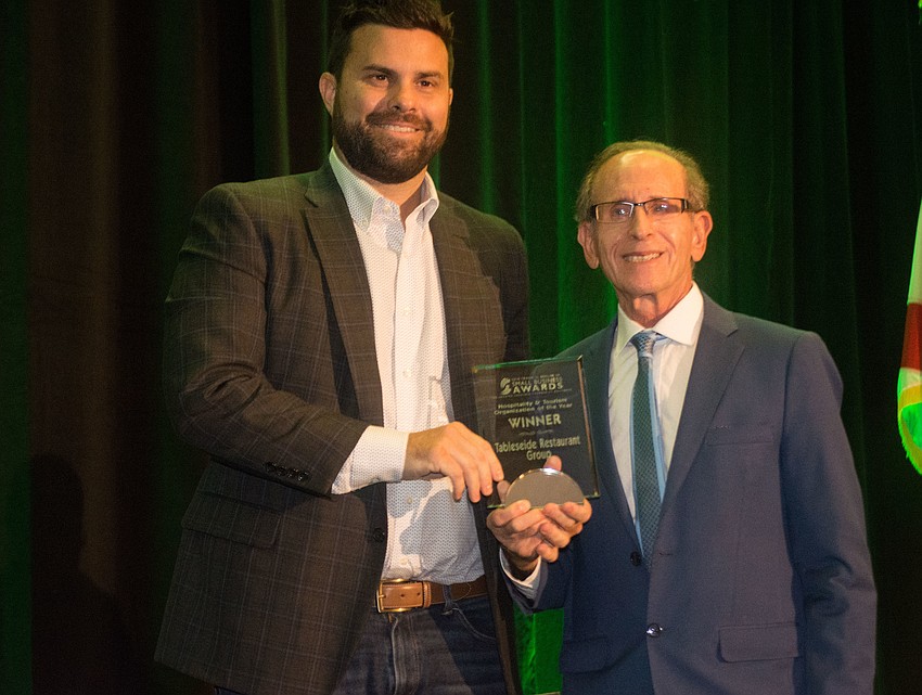 Joe Seidensticker, left, accepts the Hospitality and Tourism Organization of the Year Award from Peter Wish of the Sarasota Manatee Airport Authority.