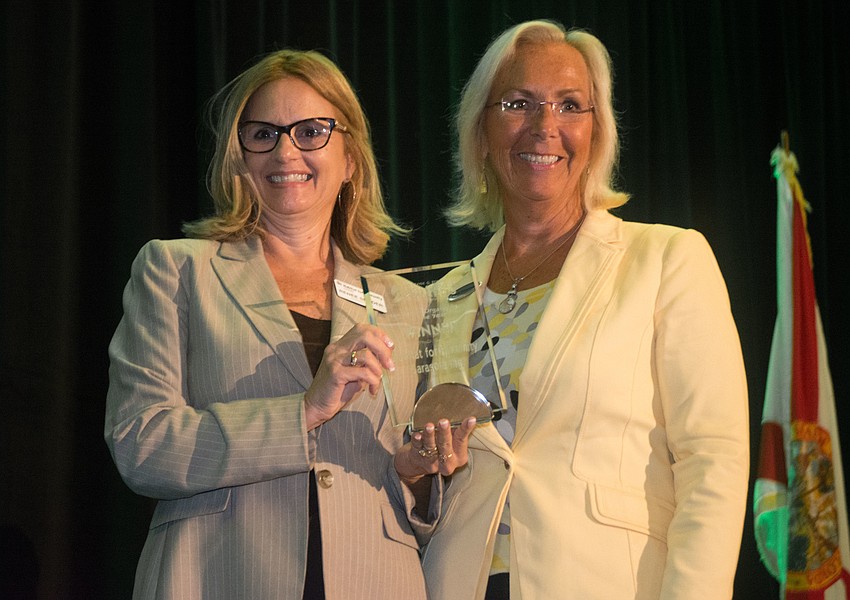 Habitat for Humanity CEO Renee Snyder accepts the award for Nonprofit Organization of the Year from Marcia Dmochowski, General Manager of Hyatt Regency Sarasota.