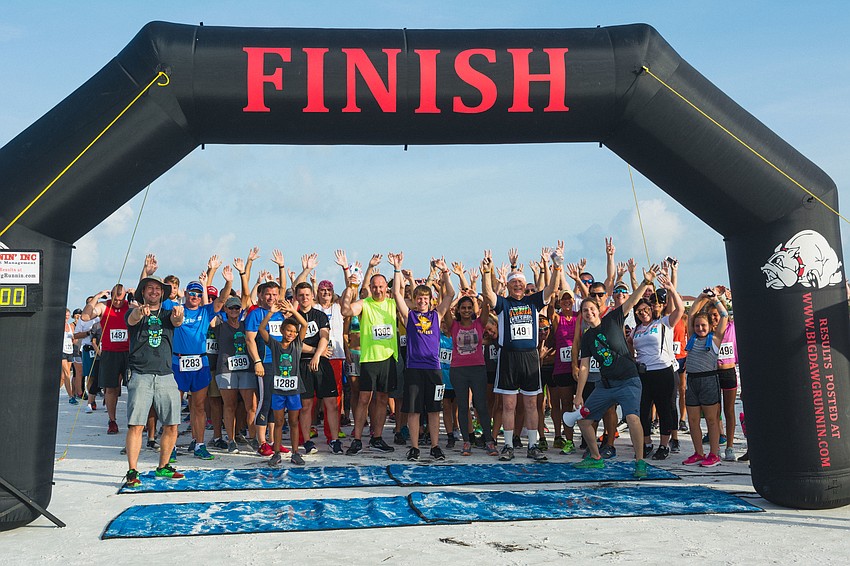 Participants take a group photo at the start and finish line before the race.