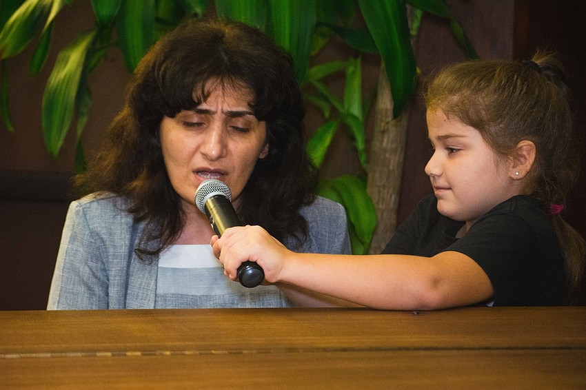 Armenian refugee Anait Maley, left, performs a ballad.