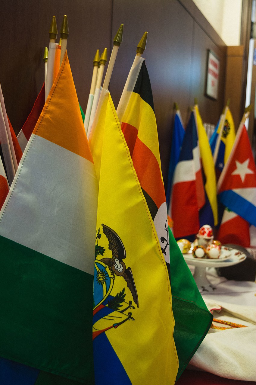 Flags from various countries lines the walls of the Selby Auditorium at USF Sarasota-Manatee for the Refugee Day event.