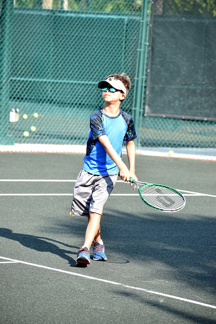 Tristan Abrams watches the ball he hit sail over the net.