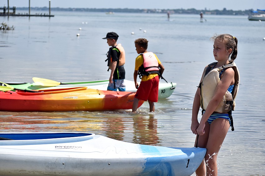 Campers pull their kayaks in the water ahead of paddle around Sarasota Bay.