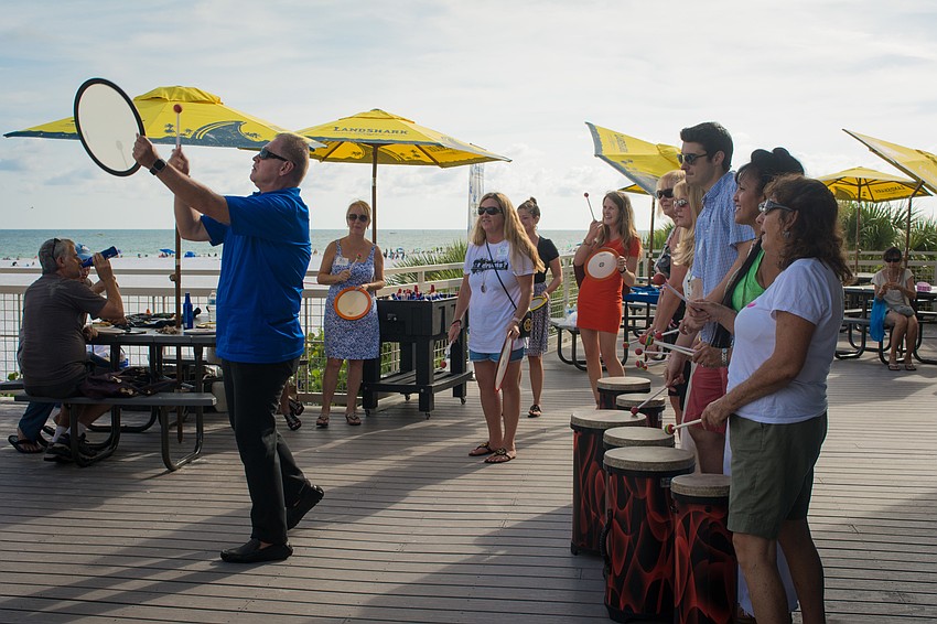 Erik Dunton leads participants in a group drumming activity.