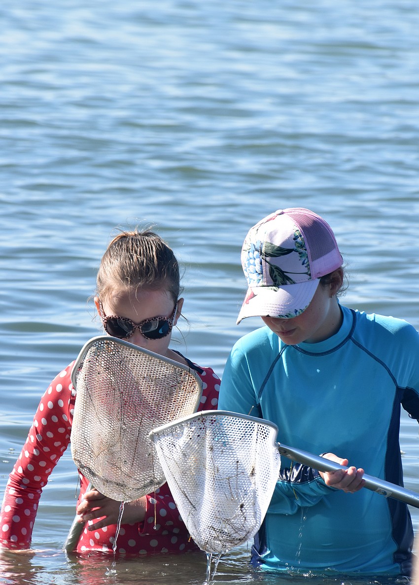 Savannah McEachern and Ava Gekht check their nets.