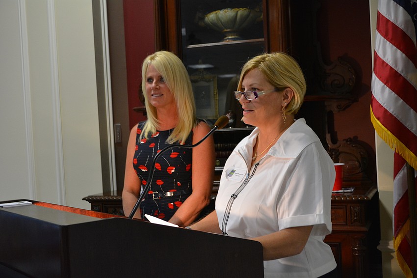 Sisterhood for Good co-founder Angela Massaro-Fain, right, co-presents a grant check with sister Kecia Dorsey.