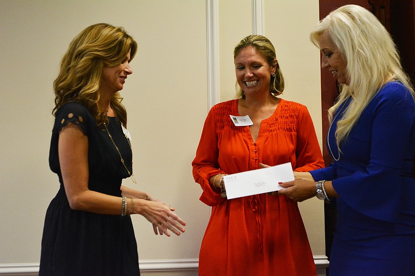 Teen Court Sarasota’s Lori Moran and Heather Todd accept a check from Sisterhood member Wanda Martinetto.