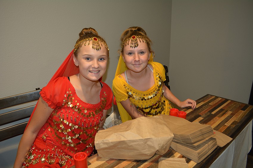 Haile Middle School students Ava McLeod and Julia Carpenter volunteer in the Cairo Marketplace, where children can buy trinkets and toys.