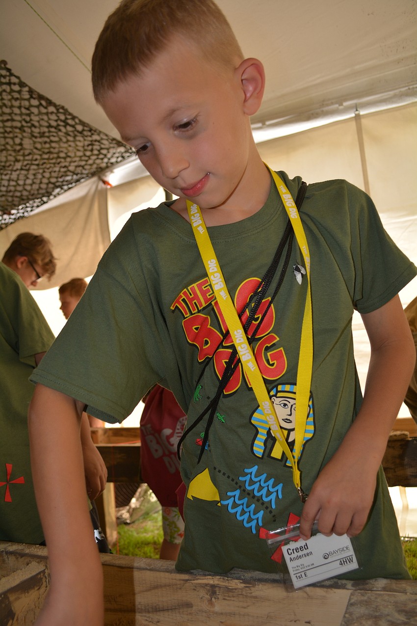 Lakeland's Creed Andersen, 7, digs for a snake in an air-conditioned tent.