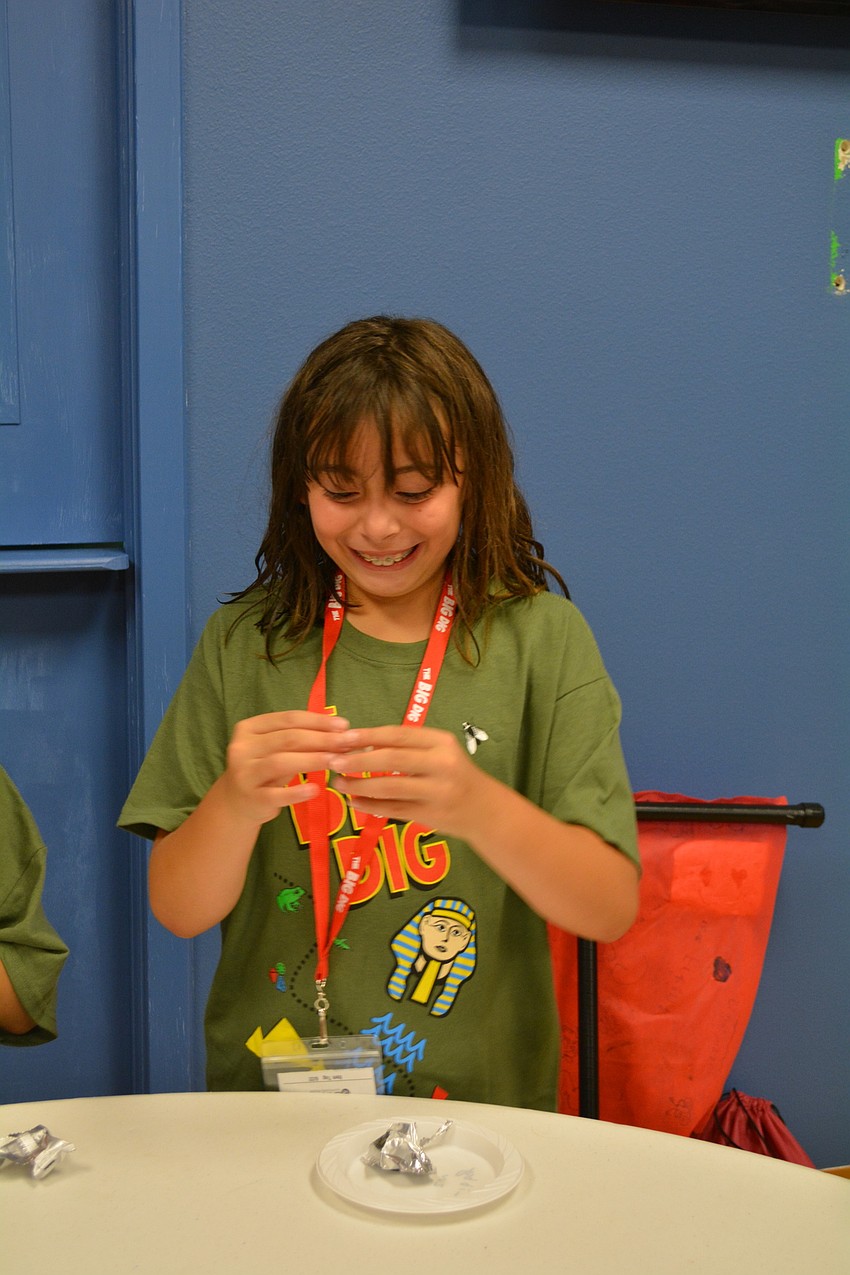 Eight-year-old Libby Joseph squeals upon feeling the clay in which she would create a 