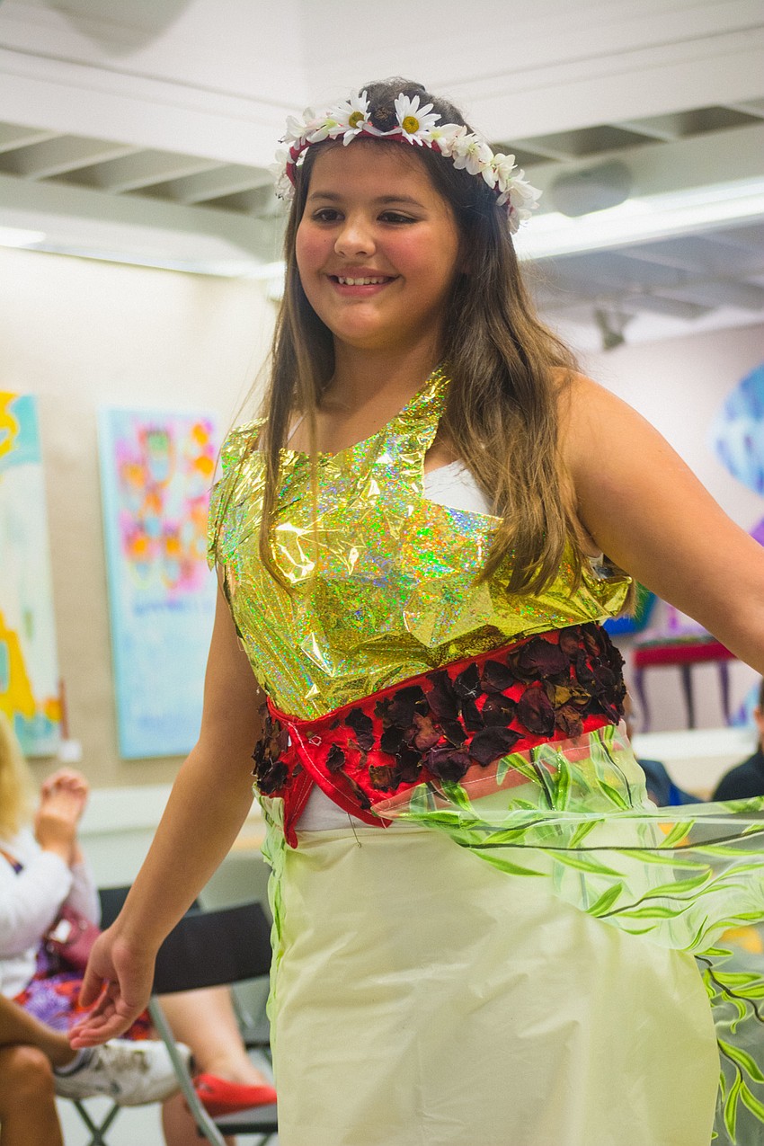 Raena Vigil wears an outfit made from materials such as shower curtains, ribbon and fake flowers.