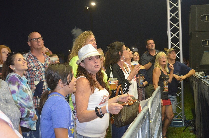 Sarasota's Laurie Cleveland (white hat) dances along with the crowd during the Greg Billings Band set.