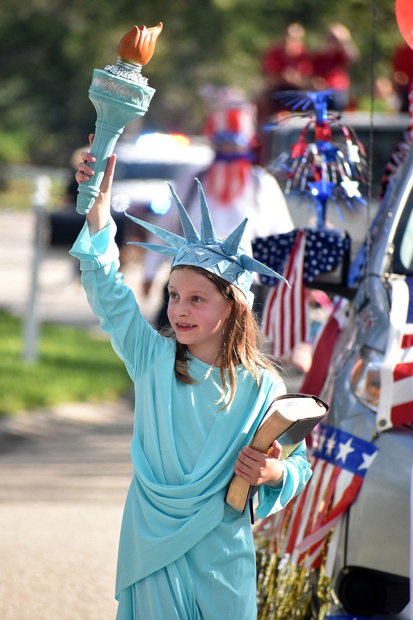 Camille Géhan walks in the parade as the Statue of Liberty.