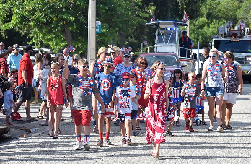 Kids in their most patriotic outfits walk the parade route.