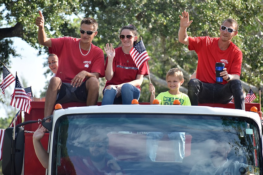 Chris Wypiszynski, Ashley Maheu, Tommy McAdams and Joshua Stewart wave to the crowd from Junk King’s truck.