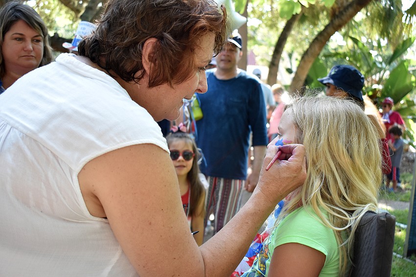 Karen Bell paints Amelia Bridges’ face.
