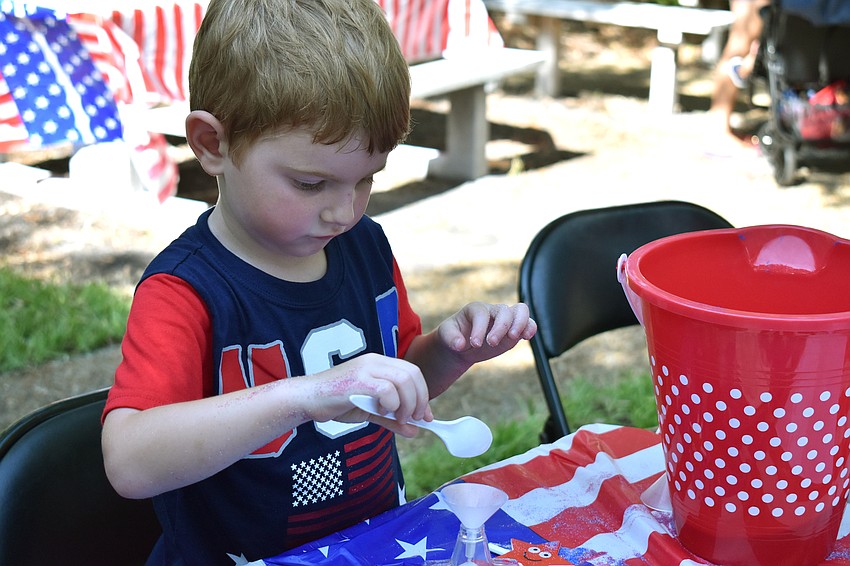 Bryson Chambers fills a plastic star with sand.