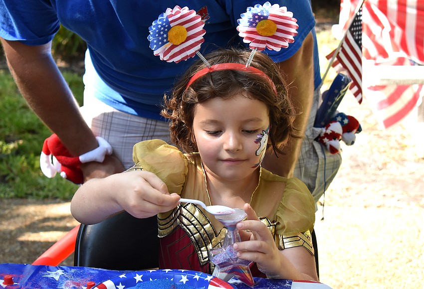 Maddy Boyer-Martinez makes sand art after the parade.