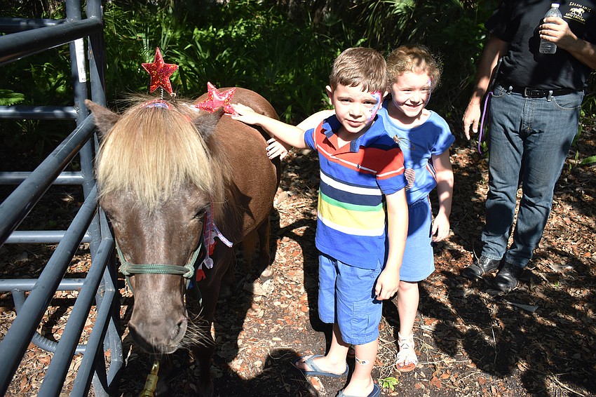 Mallory and Grayson Montminy pet a horse from Sixteen Hands Horse Sanctuary.