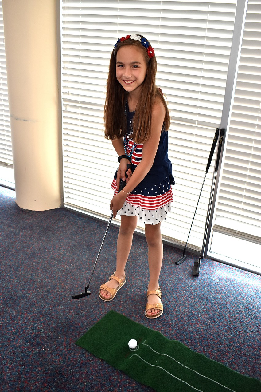 Tilli Kubisch takes a swing at mini golf.