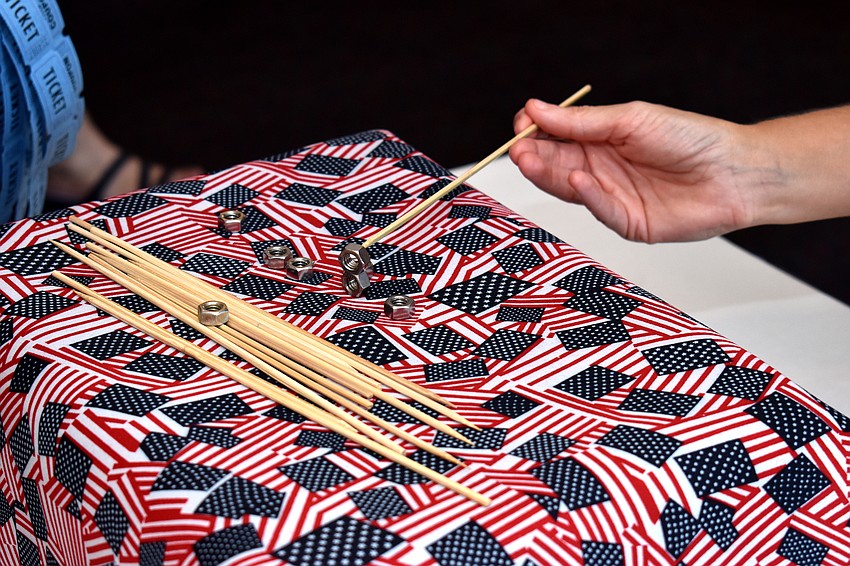 Attendees attempted many games, including this one where they had to stack small bolts.