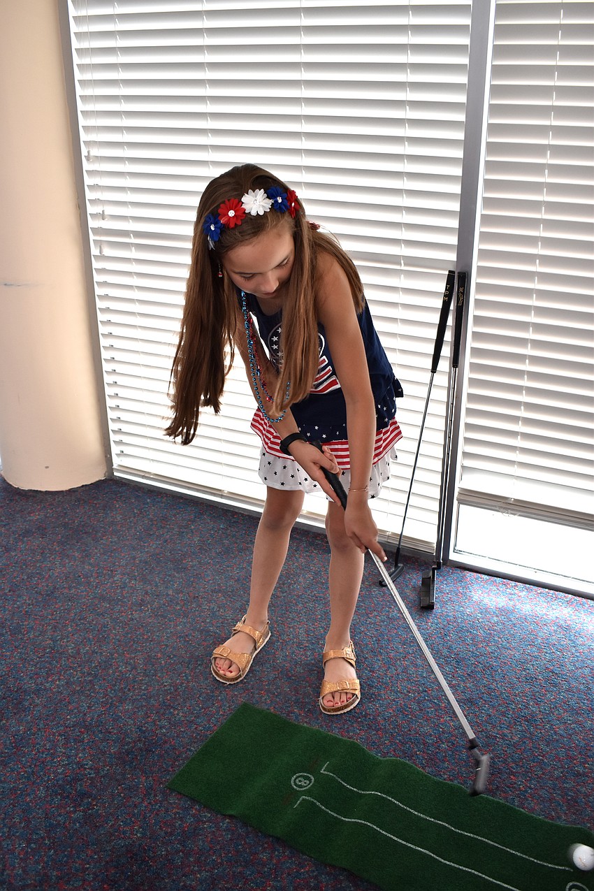 Tilli Kubisch takes a swing at mini golf.