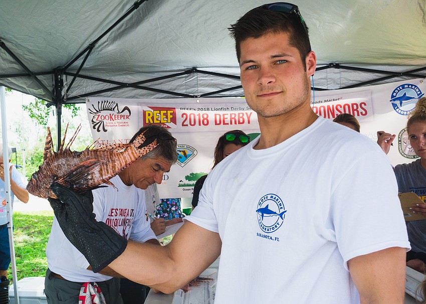 Garrett Stephens holds up one of the many caught lionfish.