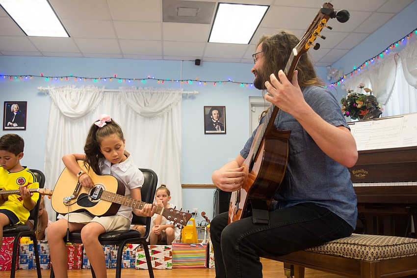 Guitar instructor Josh Scheible plays with campers during a guitar performance.