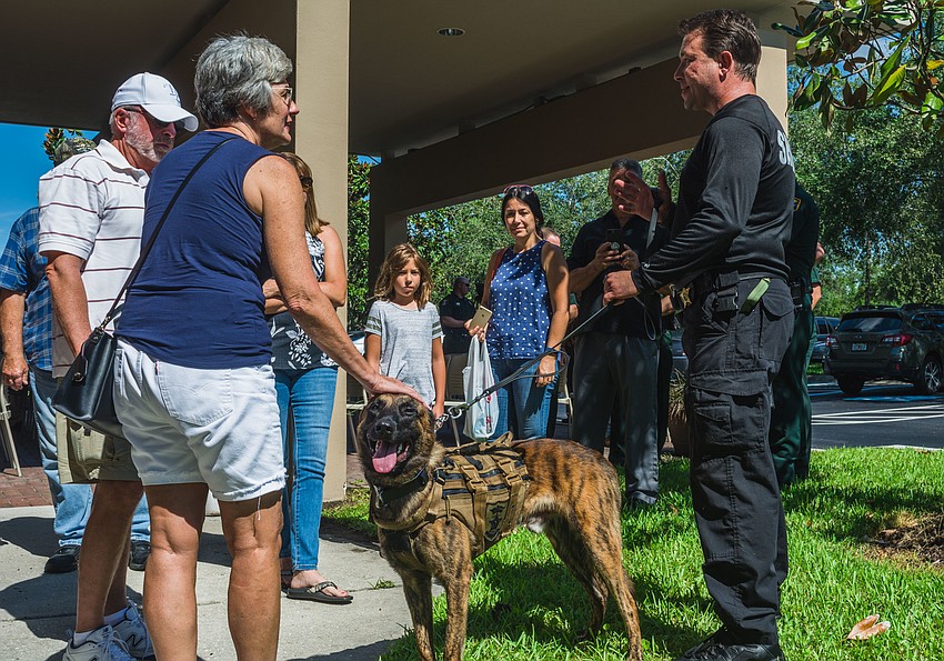 Donors who attended the event meet with  K-9 Ando, a Dutch shepherd, and his handler Deputy Kevin Skau.