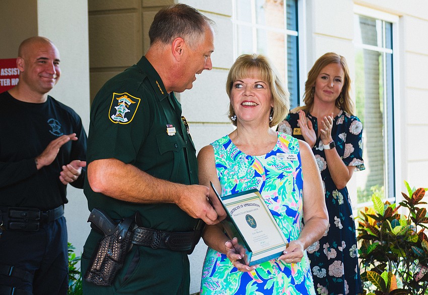 Sheriff Tom Knight presents Judy Braham with a certificate of appreciation.